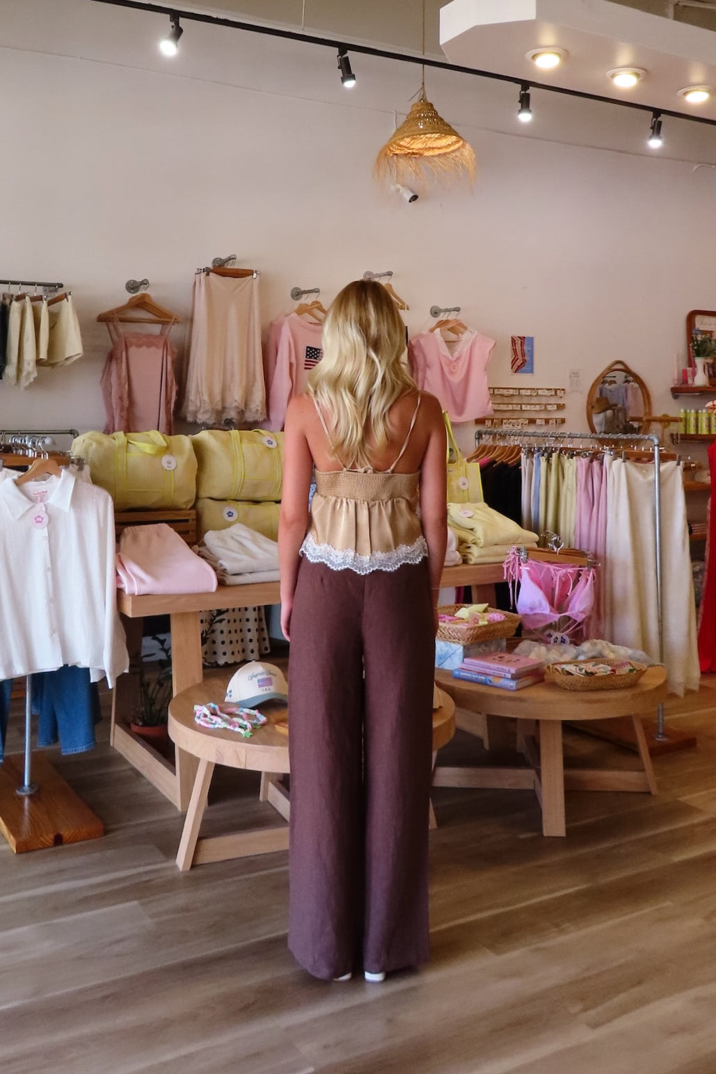 Brown, flowy linen pants with mid rise, zipper closure, wide leg, and natural textured fabric
