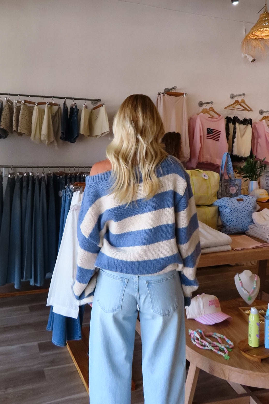 Blue, striped knit sweater with off-shoulder boat neckline and ribbed hem