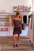 Brown, linen mini skort with with front bow, mid rise, elastic waistband, scallop lace trim, and inside shorts