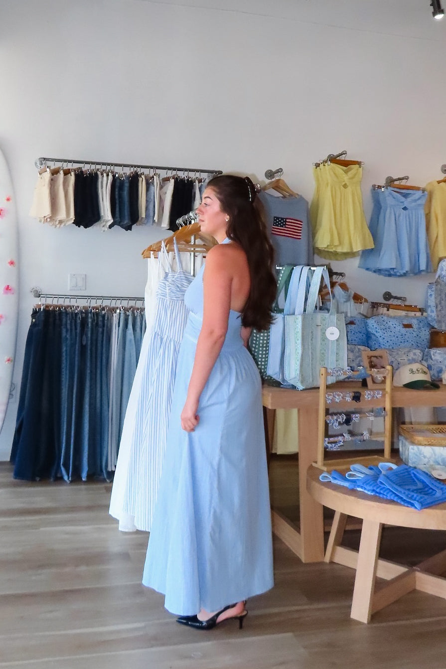 Blue, halter midi dress with V neckline, contrast thread, flare skirt, open back with smocking, and lining
Virginia Beach Boutique, 757 Boutique, fashion, summer aesthetic, women’s spring outfit, spring break, vacation style, vacation outfits, beach boutique, beach fashion, beach outfits, coastal aesthetic clothing, maxi dress, formal dress, wedding guest dress, satin slip dress, prom dress, graduation party dress