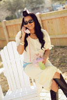 Cream, polka dot blouse with scoop neck, front buttons, puff sleeves, and ruffle trim
