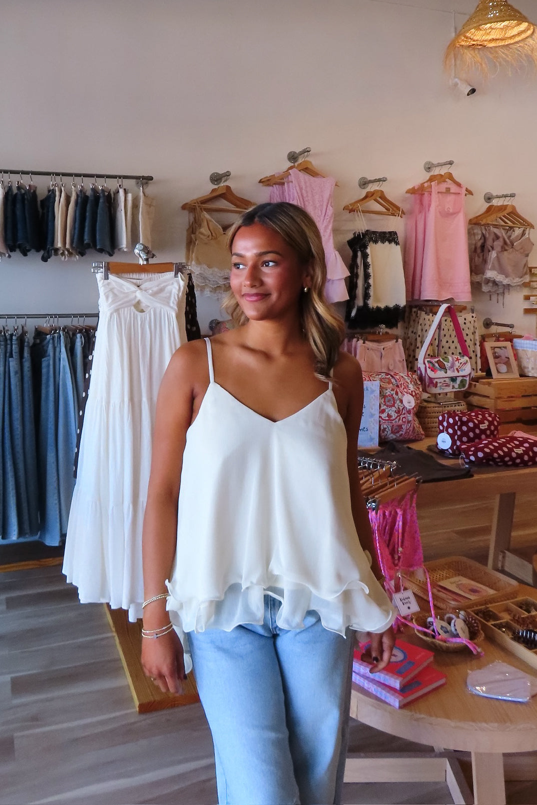 White, swing cami top with V neckline, asymmetric hem, ruffled chiffon layers, back tie, and adjustable straps