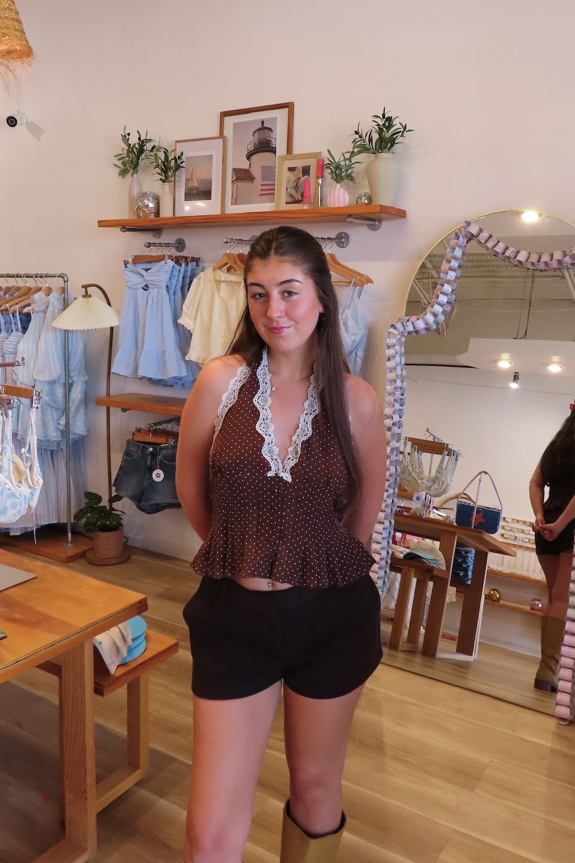 Brown, polka dot halter top with V neckline, front buttons, lace trim, smocked back, and peplum hem