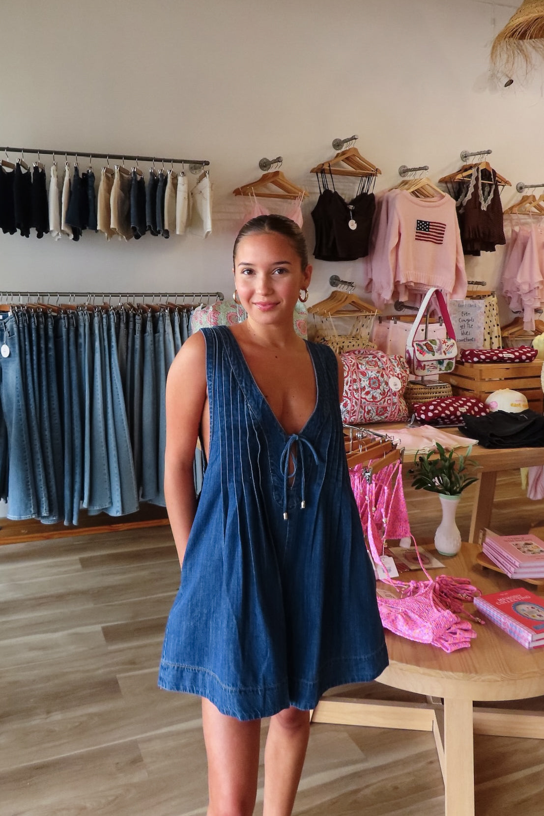 Blue, denim romper with V neckline, front tie, pockets, and pleated back