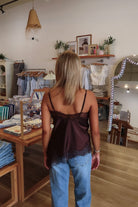 Brown, satin cami top with V neckline, asymmetric hem, scalloped lace trim, and adjustable straps, women’s lace going out top, date night lace top, asymmetrical hem top, girls night out top, vacation dinner outfit top