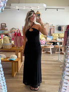 Black, maxi dress with halter neckline, front cutout, fitted bodice, and draped scarf fabric