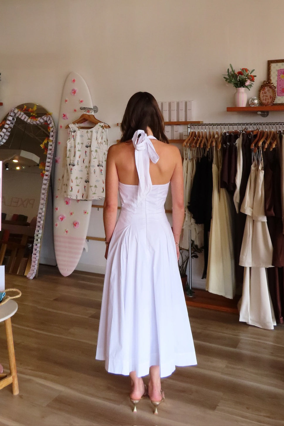 White, halter midi dress with V neckline, structured bodice, pleated skirt, and back zipper | Pixelated Boutique, Women's Clothing, Boutique Clothing for Women, Women’s Formal Dress, Women’s Occasion Dress, Maxi Dress, Wedding Guest Dress, Prom Dress, Graduation Party Dress 