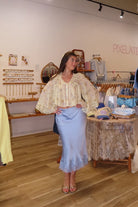 Blue, satin midi skirt with bias cut, lace hem, and side zipper, coastal cowgirl outfits, coastal aesthetic clothing, clean girl outfits, lace trim satin slip skirt, satin midi skirt, baby blue skirt for summer, low rise satin skirt, lace skirt for summer, happy hour outfit, summer satin skirt