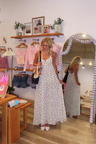 Cream, polka dot maxi dress with V neckline, keyhole cutout with button, back tie, and cross straps, Pixelated Boutique, 757 Boutique, fashion, summer aesthetic, women’s trendy summer outfit, spring break, vacation style, vacation outfits, beach boutique, beach fashion, beach outfits, coastal aesthetic clothing, maxi dress, formal dress, wedding guest dress, satin slip dress, prom dress, graduation party dress