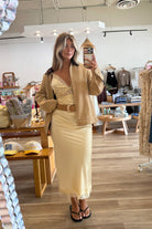 Yellow, satin maxi dress with V neckline, lace trim, open back, and adjustable cross straps