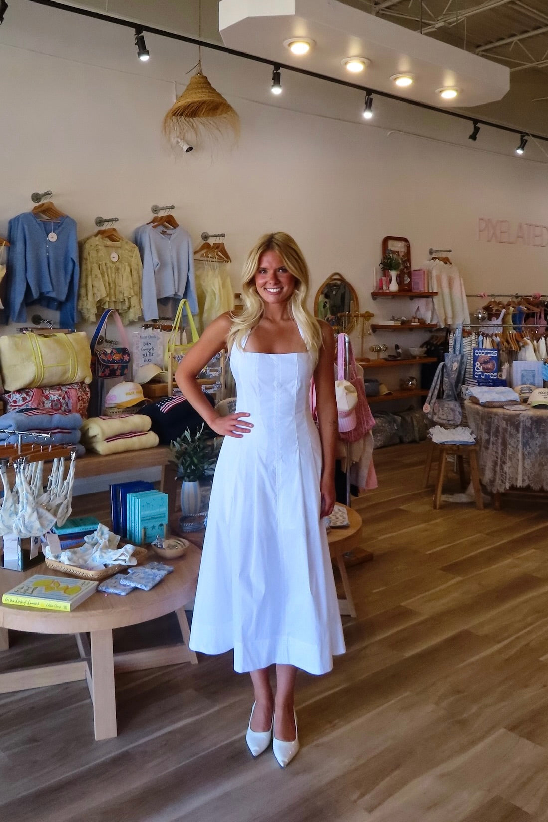 White, halter midi dress with square neckline, structured bodice, flared skirt, and side pockets | Pixelated Boutique, Virginia Beach Boutique, white maxi dress, white lace dress, boho maxi dress, bridal shower dress, bachelorette dress, graduation dress