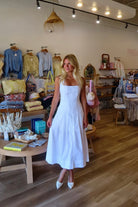 White, halter midi dress with square neckline, structured bodice, flared skirt, and side pockets | Pixelated Boutique, Virginia Beach Boutique, white maxi dress, white lace dress, boho maxi dress, bridal shower dress, bachelorette dress, graduation dress
