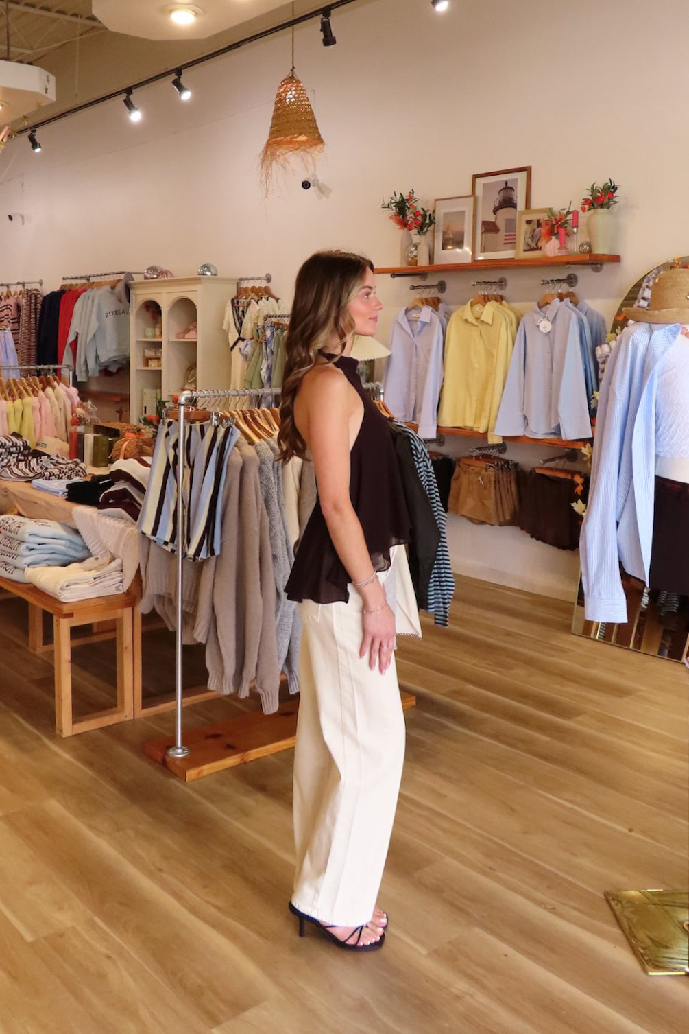 Brown, halter top with a high neckline, open back, flowy silhouette, asymmetrical hem, semi-sheer fabric, and full lining