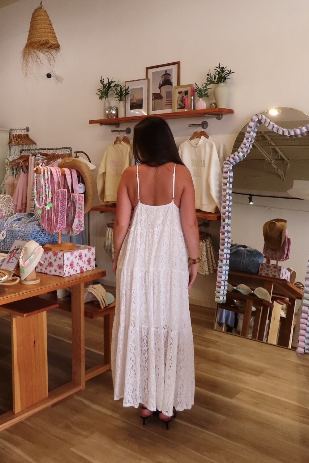 White, lace maxi dress with V neckline, empire waist, tiers, adjustable straps, 3/4 lined interior, and open back