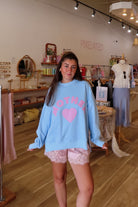 Blue, gingham heart and “MOTHER” embroidered in pink sweatshirt with crew neckline and fleece lining. Oversized and slightly cropped.

By The Beach Club