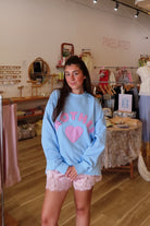 Blue, gingham heart and “MOTHER” embroidered in pink sweatshirt with crew neckline and fleece lining. Oversized and slightly cropped.

By The Beach Club