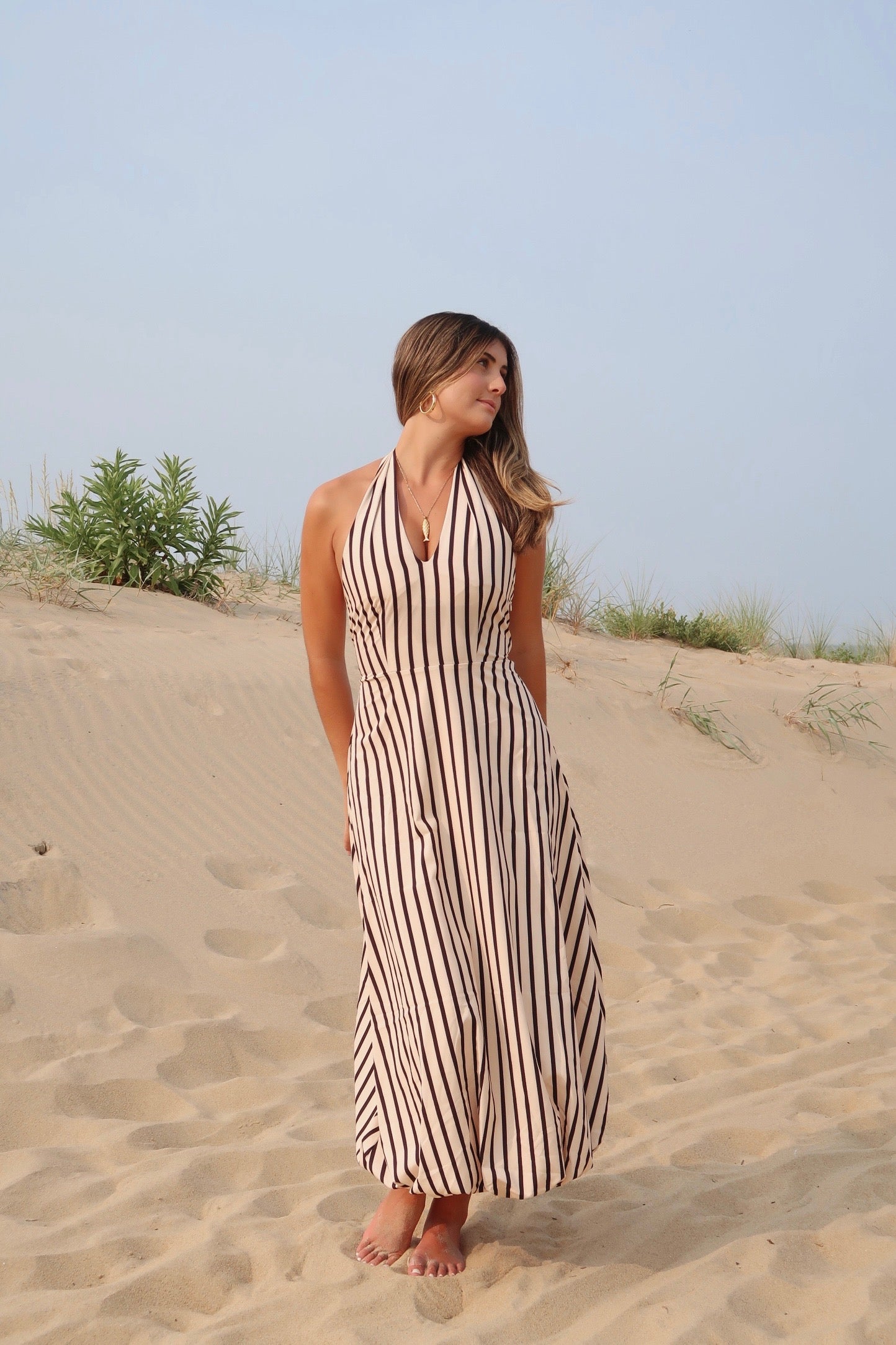 Tan and black, striped maxi dress with V neckline, halter tie, open back, and bubble hem | Pixelated Boutique, Women's Clothing, Boutique Clothing for Women, Women’s Formal Dress, Women’s Occasion Dress, Maxi Dress, Wedding Guest Dress, Prom Dress, Graduation Party Dress 