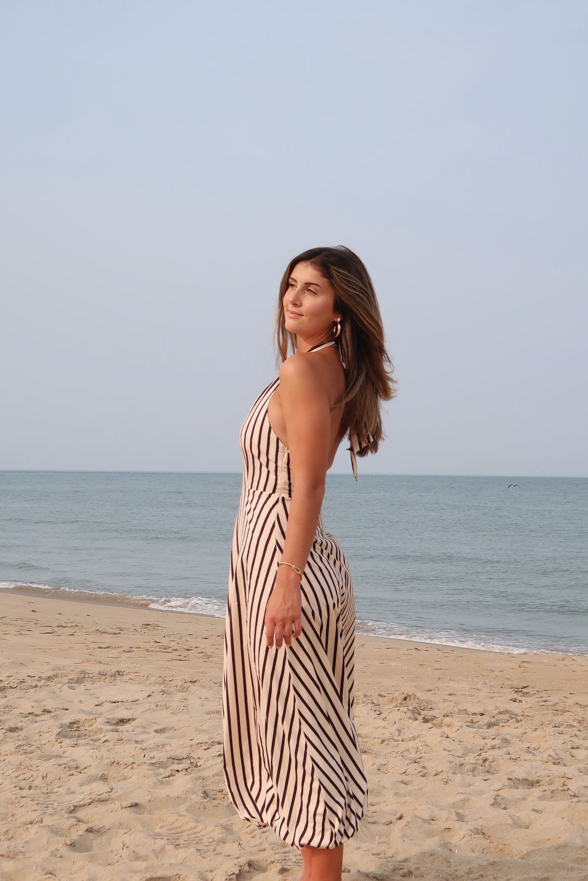 Tan and black, striped maxi dress with V neckline, halter tie, open back, and bubble hem | Pixelated Boutique, Women's Clothing, Boutique Clothing for Women, Women’s Formal Dress, Women’s Occasion Dress, Maxi Dress, Wedding Guest Dress, Prom Dress, Graduation Party Dress 
