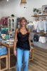 Black, satin cami top with V neckline, asymmetric hem, scalloped lace trim, and adjustable straps, women’s lace going out top, date night lace top, asymmetrical hem top, girls night out top, vacation dinner outfit top