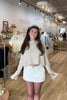 Tan, knit sweater with drop shoulder, front pocket, slit sleeves, and cropped length
