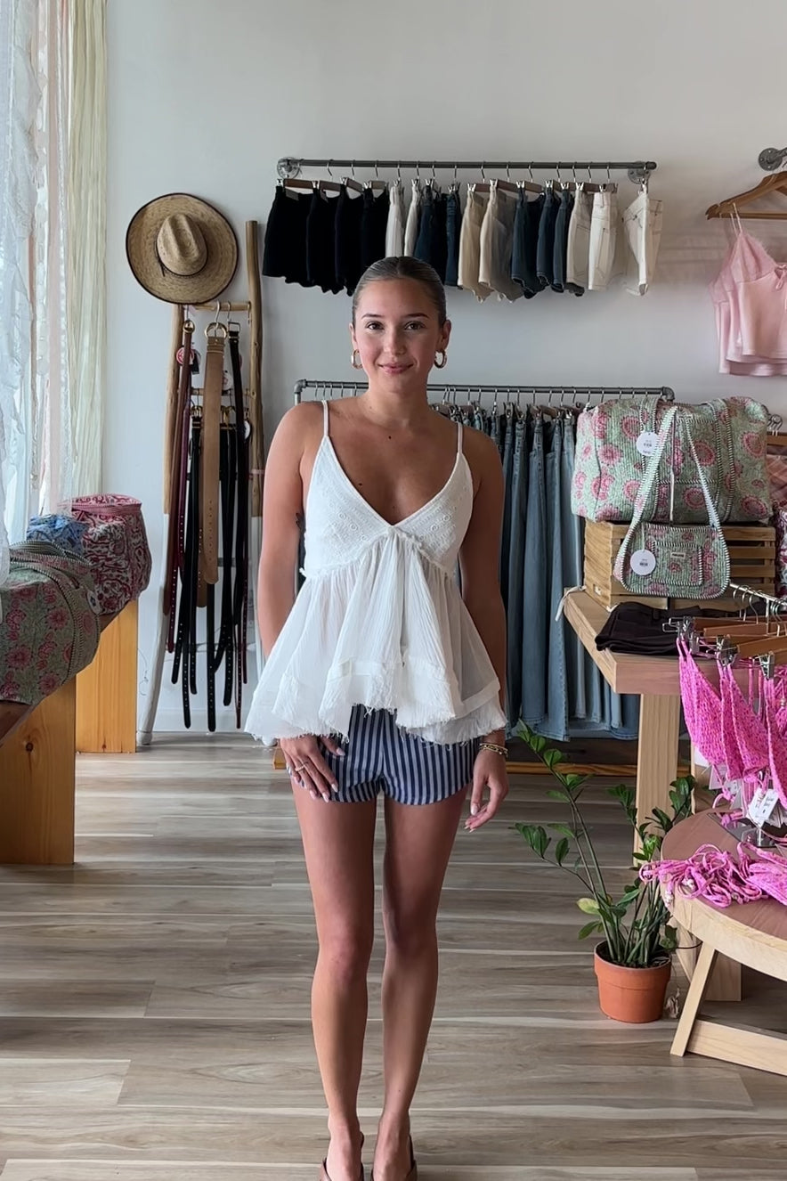 White, babydoll tiered top with V neckline, gathered bust, raw hem, crinkle gauze fabric, and adjustable Straps, beach boutique, beach fashion, beach outfits, women’s boutique clothing, boutique clothing for women, coastal cowgirl outfits, coastal aesthetic clothing