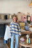 Blue, striped knit sweater with off-shoulder boat neckline and ribbed hem