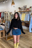 Black, knit sweater with drop shoulder, front pocket, slit sleeves, and cropped length