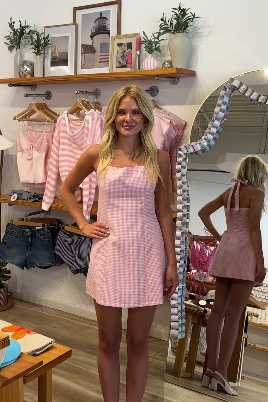 Pink, gingham mini dress with halter neckline, tie neck, and back zipper, pink plaid mini dress, farmer's market dress, trendy casual dresses for summer, summer mini dress, vacation style, vacation outfits, beach boutique, beach fashion, beach outfits, coastal aesthetic clothing